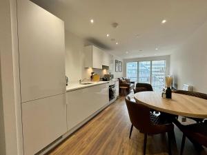 a kitchen and dining room with a table and a counter at Luxury 2 bed Apartment Bracknell in Bracknell
