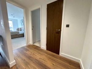 een hal met een houten deur en een slaapkamer bij Luxury 2 bed Apartment Bracknell in Bracknell