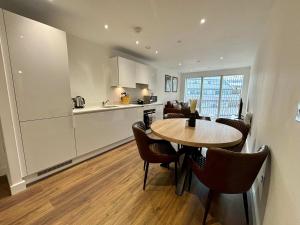 een keuken en woonkamer met een tafel en stoelen bij Luxury 2 bed Apartment Bracknell in Bracknell