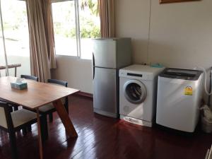 a kitchen with a refrigerator and a washing machine and a table at Nakara Samui-2 bedrooms Ocean View in Ban Thong Phlu