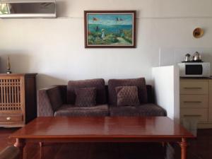 a living room with a couch and a table at Nakara Samui-Deluxe beach front in Ban Thong Phlu