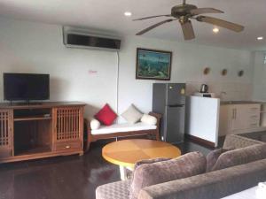 a living room with a couch and a table and a refrigerator at Nakara Samui-Deluxe beach front in Ban Thong Phlu