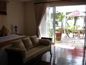 a bedroom with a bed and a couch and a patio at Nakara Samui-Deluxe beach front in Ban Thong Phlu +29 photos