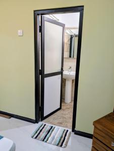 una puerta abierta a un baño con lavabo en Greenlight Stay, en Ambalangoda