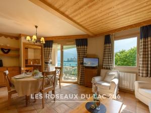 a living room with a table and a couch at Les Roseaux du Lac - 7 appartements situés dans une résidence posée au bord du lac d'Annecy in Duingt