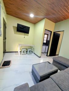 Una sala de estar con una mesa y un televisor. en Greenlight Stay, en Ambalangoda