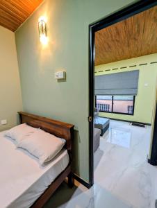 Un dormitorio con una cama y una puerta corrediza de vidrio. en Greenlight Stay, en Ambalangoda
