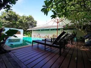 a deck with two chairs and a swimming pool at Nakara Samui S4 Two Bedrooms Apt in Ban Thong Phlu