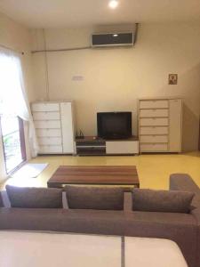 a living room with a couch and a flat screen tv at Nakara Samui S4 Two Bedrooms Apt in Ban Thong Phlu