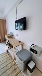Una habitación con una mesa y un televisor en la pared. en Holiday House Kata & Karon Phuket Hotel, en Kata Beach