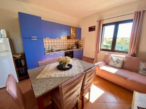 a kitchen and living room with a table and a couch at Pupureddu con Terrazza ad Olbia in Olbia