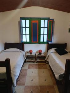 a bedroom with two beds and a window at La Cigarra Casa de Huéspedes in Salento