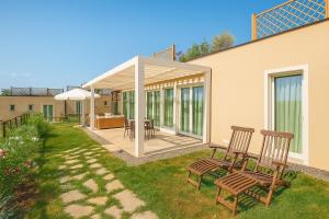 a patio with two chairs and an umbrella at Hotiday Lodge Cecina in Cecina