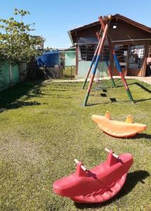 a playground with two slides and a swing set at Chácara in Franco da Rocha