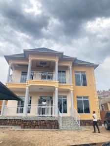 2 personnes debout sur le balcon d'une maison dans l'établissement Secret Stay inn and hotel, à Kigali