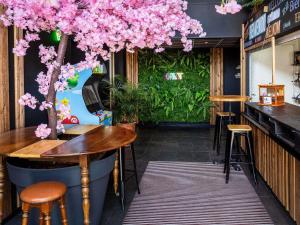 a bar with pink flowers hanging from the ceiling at Greet Hotel Limoges Nord in Limoges