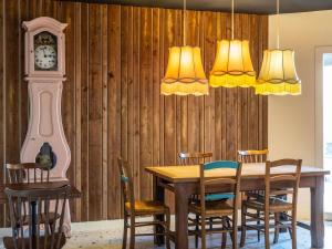 comedor con mesa y reloj de abuelo en Greet Hotel Limoges Nord, en Limoges