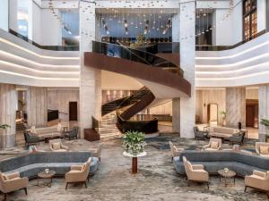 un vestíbulo de un hotel con sofás y una escalera en Sofitel Cairo Downtown Nile, en El Cairo