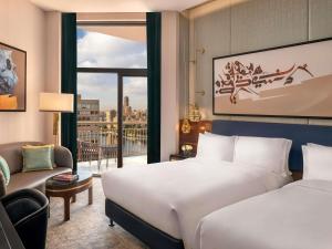 Una habitación de hotel con una cama, un sofá y una ventana. en Sofitel Cairo Downtown Nile, en El Cairo