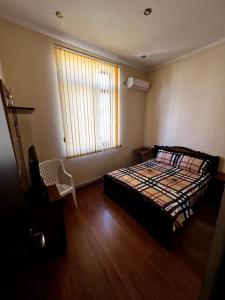 een slaapkamer met een bed, een raam en een stoel bij Tatev in Jerevan