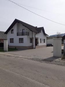 une maison blanche avec un parking à côté d'une rue dans l'établissement Green Garden, à Sighetu Marmaţiei