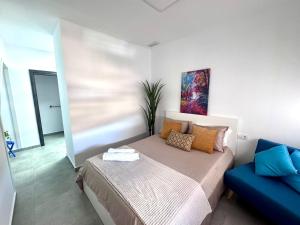 Un dormitorio con una cama y un sofá azul. en AZUL, en Bolnuevo