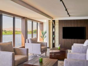 - un salon avec une télévision, un canapé et des chaises dans l'établissement Mövenpick Royal Lily Nile Cruise, Every Monday Four Nights From Luxor, Every Friday Three Nights From Aswan - Including Excursions & Sightseeing, à Louxor