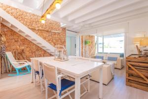 a kitchen and dining room with a white table and chairs at Can Bosquerró in Sa Ràpita