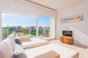 a living room with a white couch and a large window at Can Bosquerró in Sa Ràpita