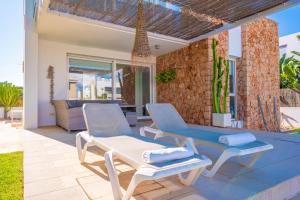 a patio with two lounge chairs and a table at Can Bosquerró in Sa Ràpita