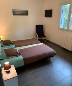 a bedroom with two beds and a chair in it at Villa jacuzzi entre Lac et Ocean in Cazaux
