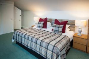 a bedroom with a large bed with red pillows at The Penthouse Self Catering in Nairn