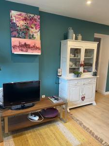 a living room with a television and a white cabinet at logement au calme 