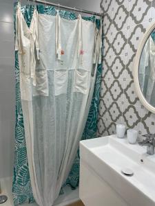 a bathroom with a sink and a shower curtain at logement au calme 