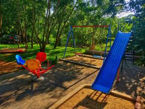 a playground with two swings and a slide at Sun Farm Retreat in Auroville
