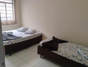 a bedroom with two beds and a window at Apartamento com 3 quartos a só 200 metros da Basílica in Aparecida