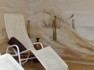 two white chairs in a room with a painting on the wall at Hotel Schmidt am Markt in Meppen