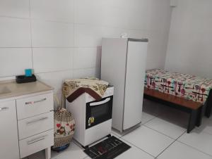 a small kitchen with a refrigerator and a table at Apartamento com 3 quartos a só 200 metros da Basílica in Aparecida +1 photo