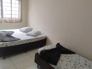 two twin beds in a room with a window at Apartamento com 3 quartos a só 200 metros da Basílica in Aparecida