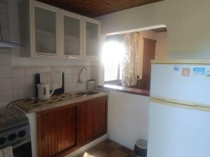 a kitchen with a white refrigerator and a sink at Casa Baqué in Colonia del Sacramento