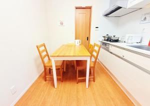 a small kitchen with a wooden table and chairs at 池袋本町101 in Tokyo