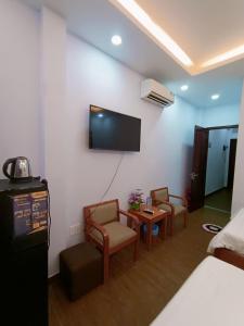 a room with a bed and a tv on a wall at 102 House in Ho Chi Minh City