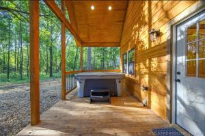 a porch with a tub in the middle of a house at Bear with Me Cabin in Broken Bow in Broken Bow