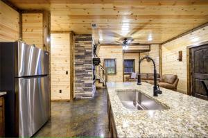 a kitchen with a sink and a refrigerator in a cabin at Bear with Me Cabin in Broken Bow in Broken Bow
