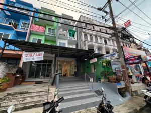 a building with two motorcycles parked in front of it at Abdullah Residence in Patong Beach