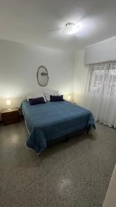une chambre avec un lit avec une couverture bleue dans l'établissement Piriapolis apartamento, à Piriápolis