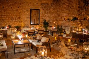a room with tables and chairs and a stone wall at Heritage Hotel Maskovica Han in Pakoštane +61 photos