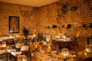 a restaurant with tables and chairs and a brick wall at Heritage Hotel Maskovica Han in Pakoštane