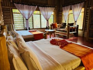 a bedroom with two beds and a living room at The Great Outdoors Uganda in Vumba