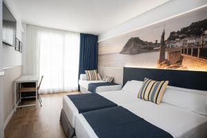 Una habitación de hotel con dos camas y una ventana. en Hotel Don Juan Tossa, en Tossa de Mar